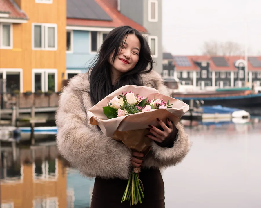 Een lachend portret met bloemen aan het water